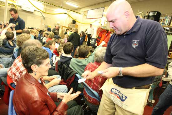 Lucille Hughes purchases a ticket from firefighter Bill McElhaney.