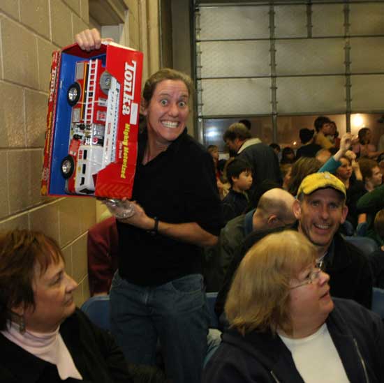 Marisa Steele offers a cheesy grin as she holds up her winnings, a toy firetruck.