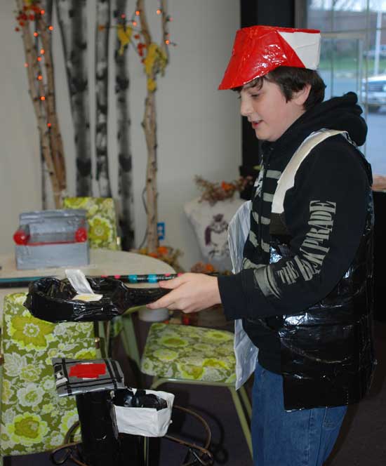 Jack Chambers tries out the stove, pan, and eggs he made from duct tape, while wearing a cook’s hat and vest he also created.
