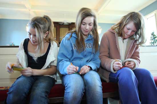 Olivia Alfano, Sofia Catalina, and Hannah Wharton fill out raffle tickets at the Congregational Church.