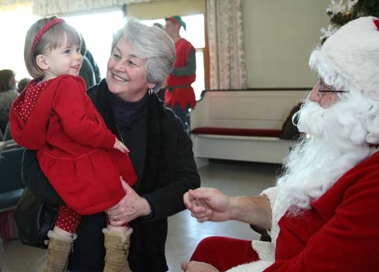 Cassidy Lee is all smiles as her grandmother Dee Lee delivers her to Santa.