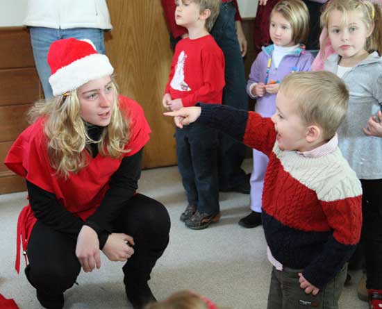Sara Collins speaks with Russell Kilkenney as he waits to sit in Santa’s lap.
