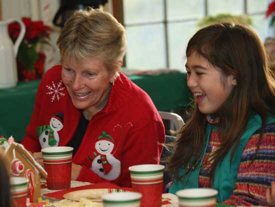 Pat Jennings and Amy Hunter admire a gingerbread house at the annual senior holiday tea put on by the Girl Scouts at the Congregational Church.