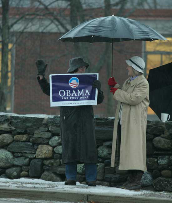 Connie Larrabee and Kathy Hewitt catch up while campaigning in front of Bromfield on a rainy February morning.