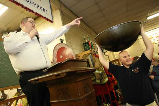 Andrew Perry points to a winner as Wally Shaw holds a cauldron of tickets at the annual Firefighters Turkey Raffle.