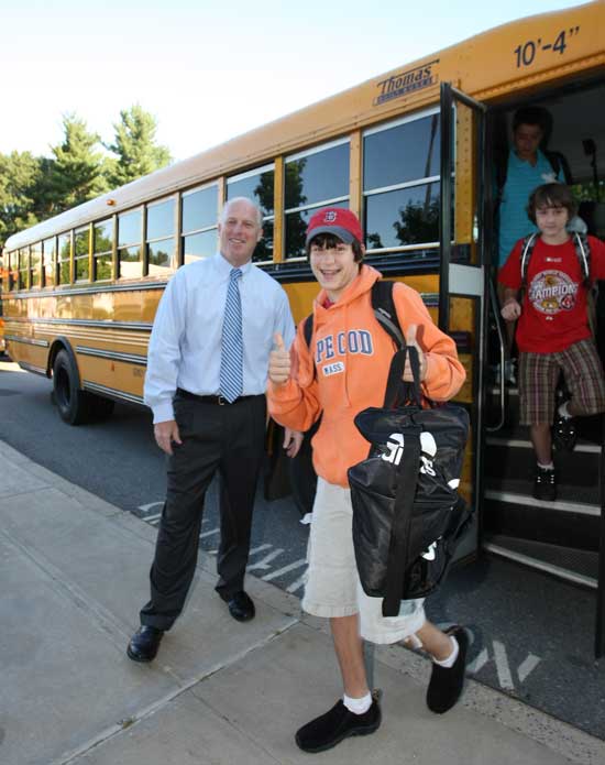Principal Jim O'Shea greets Erik Johnson as he step off the bus at Bromfield on the first day of school.