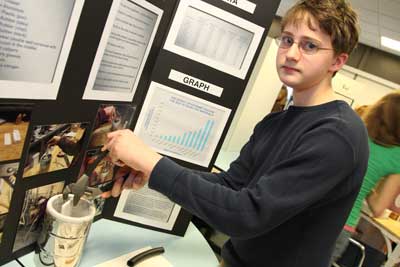 Jeff Blanton demonstrates the effect of temperature on building materials as he pulls a tile out of a container filled with liquid nitrogen.