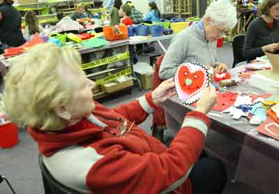 Joyce Carrick assesses her work as Sue Barber contines to work on her Valentine at Art and Cloth on Saturday.