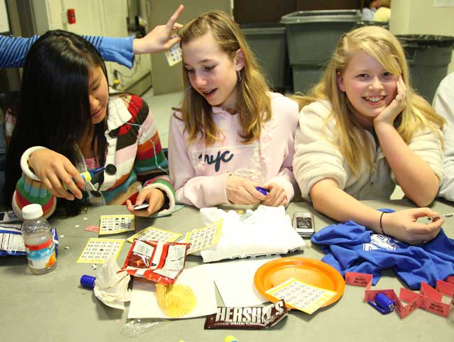 Jen Symula, Kristen Noyes, and Lena Karotkin settle in with a game and a bunch of treats.