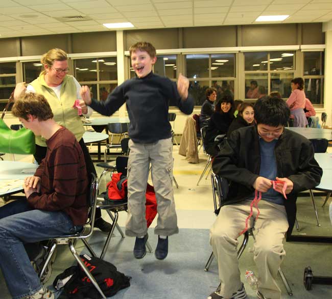 Michael Jacoby flies off the floor when he finds out he has won the cash raffle at family game night.
