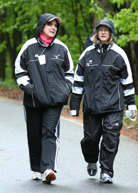 Terry Symula (left) and Karen Shea walk down Stow Road on the first of what would turn out to be three rainy days of the Just ’Cause walk to raise awareness of breast cancer and money for research. (Photo by Lisa Aciukewicz)