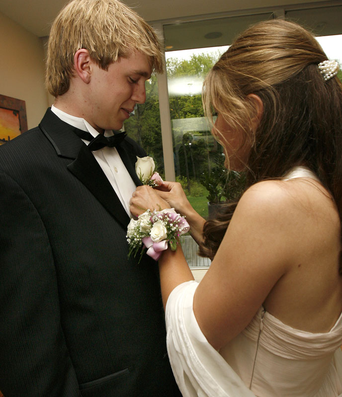 Eliza Ives pins a boutonniere on the lapel of Brian Morgan’s tuxedo before the prom. (Photo by Ellen Harasimowicz)